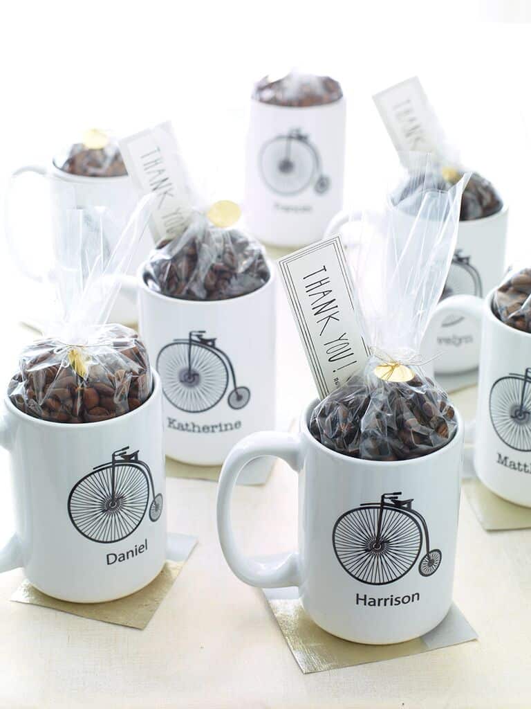 Canecas com nome dos convidados e grãos de café.