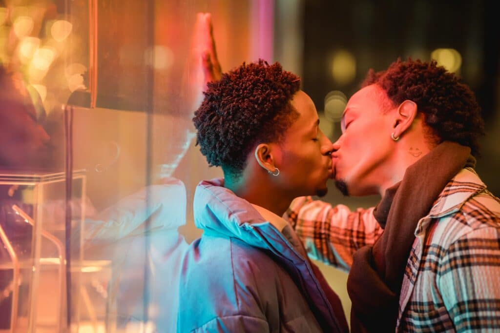 Casal de homens gays negros se beijando. A Lua de Mel dá a oportunidade de o casal passar tempo junto e se conhecer profundamente. (Foto: Uriel Mont/Unsplash)